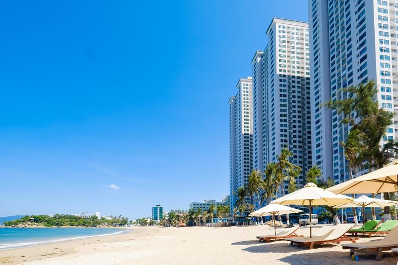 White beach umbrellas and sun loungers on the sand near Sunrise Apartment