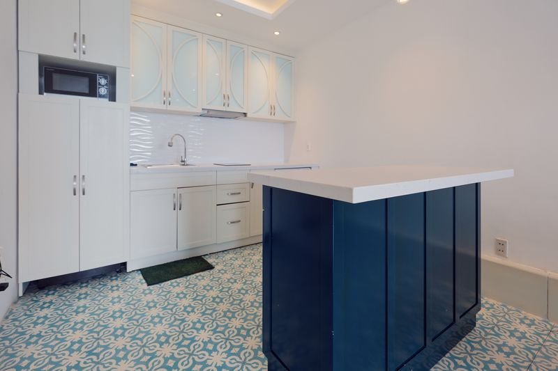 White kitchen with navy island and patterned cement tiles