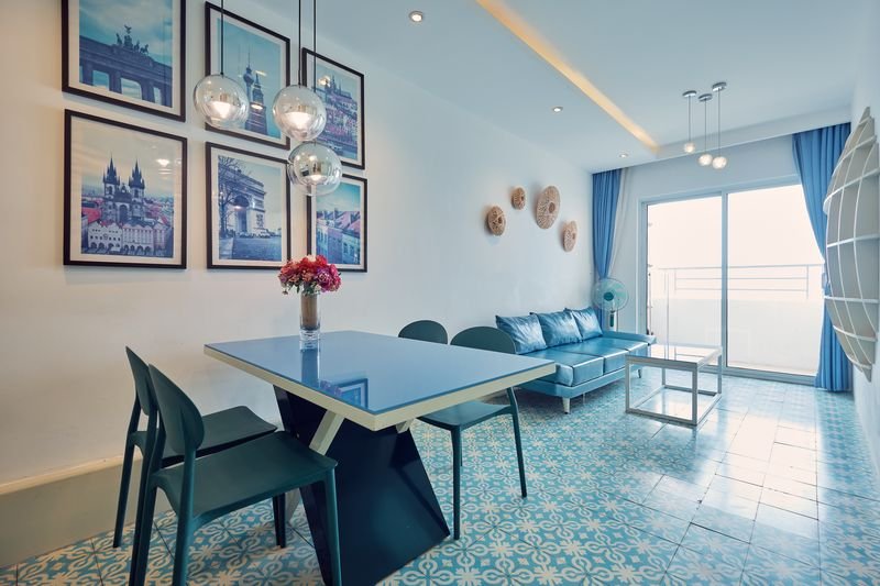 Sun-lit living room with pale blue curtains and sofa