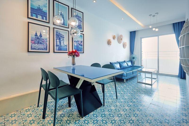 Dining table for four under pendant lights with gallery wall