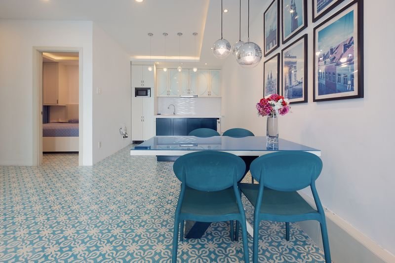Dining area with blue-framed travel prints and designer chairs
