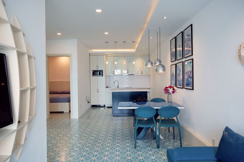 Living space with sculptural TV wall and kitchen view